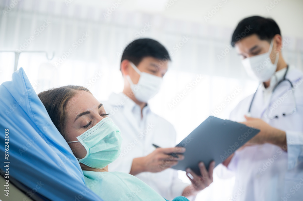 The doctor team take a medical care and treatment to contagious disease patient with the vaccine and drug by using face mask and PPE protection at the health care hospital