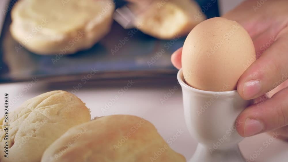 Person eating soft boiled egg for breakfast. Person eating soft boiled egg for breakfast.