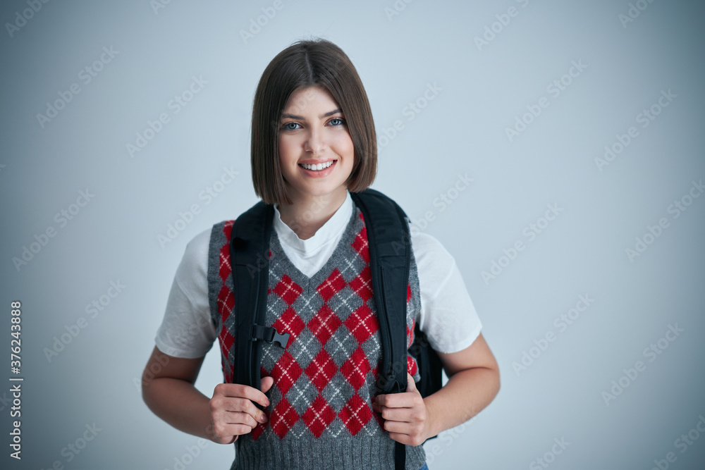 Happy young positive student posing over bright background Happy young positive student posing over bright background
