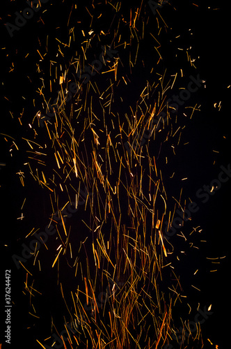 People dance at night around a big fire