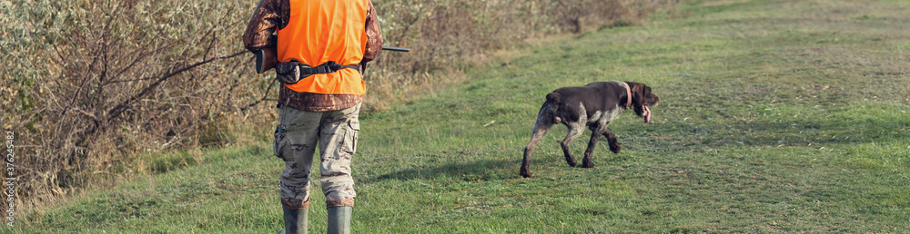 Hunter man in rural field with shotgun and backpack during hunting season Hunter man in rural field with shotgun and backpack during hunting season