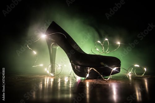 Фотография Silhouette of a high heel women shoes at dark