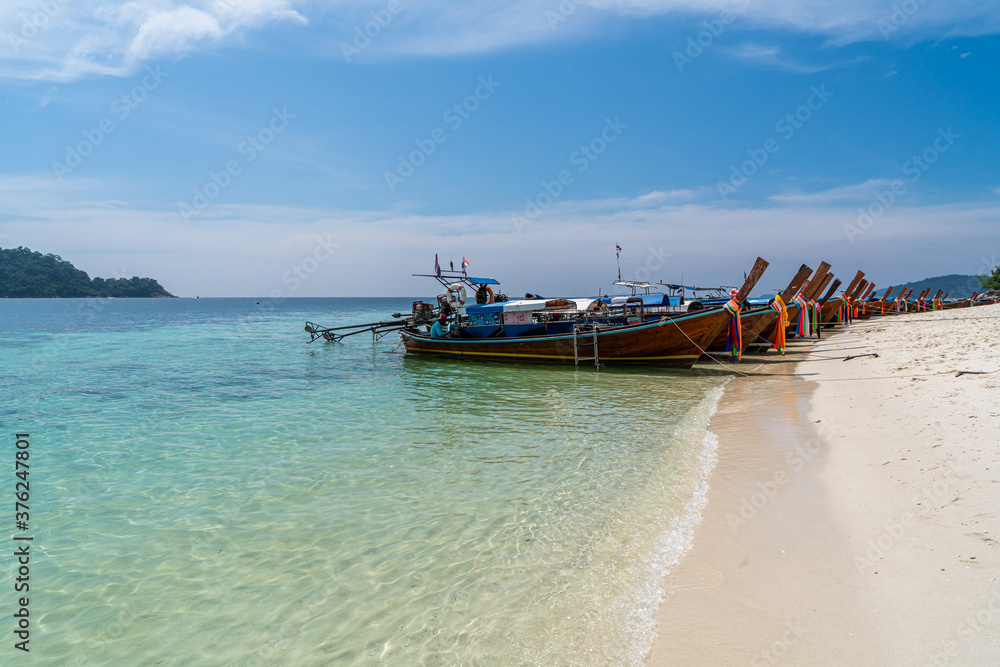 Traditional long tail boats in crystal clear water in Sai Khao Beach, Ra Wi Island, Southern of Thailand