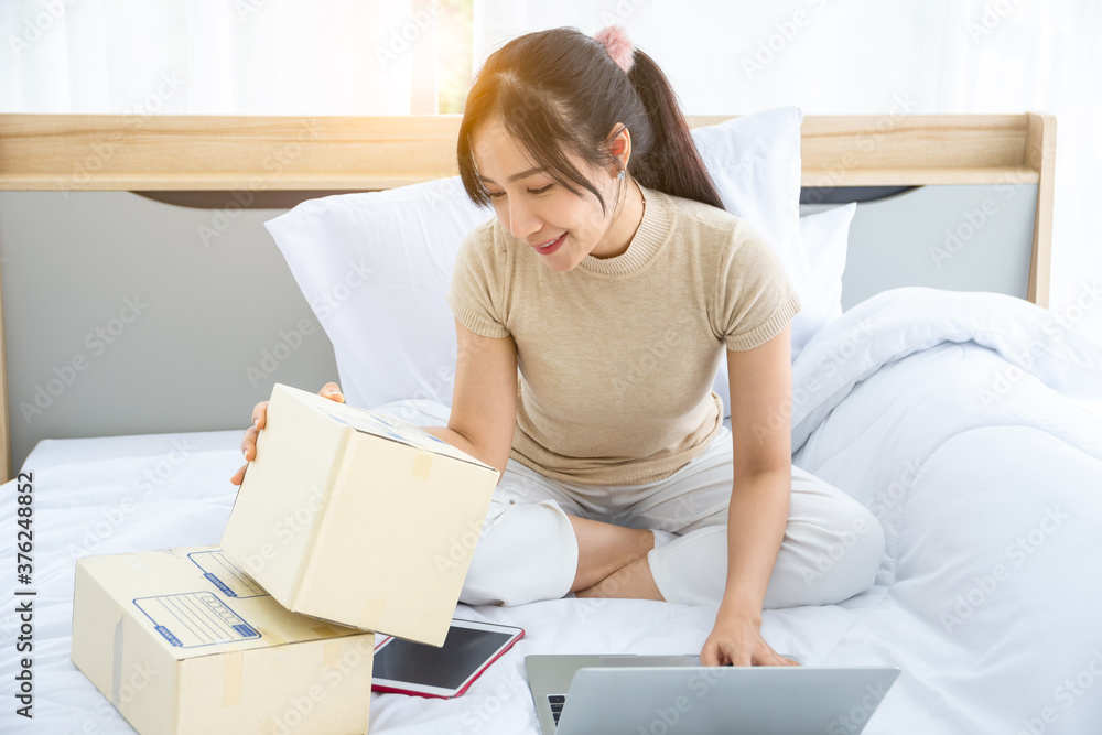A girl sitting on bed with a laptop Receive orders from customers and deliver them to the address provided by the customer. A girl sitting on bed with a laptop Receive orders from customers and deliver them to the address provided by the customer.