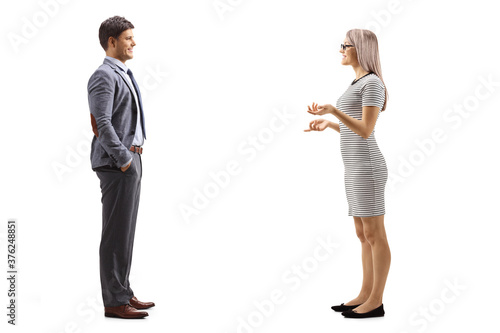 Full length profile shot of a young woman having a conversation with a man