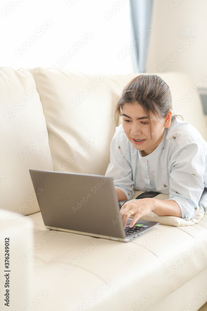 Young women working on laptops looking online And relax comfortably in the living room in the house Young women working on laptops looking online And relax comfortably in the living room in the house