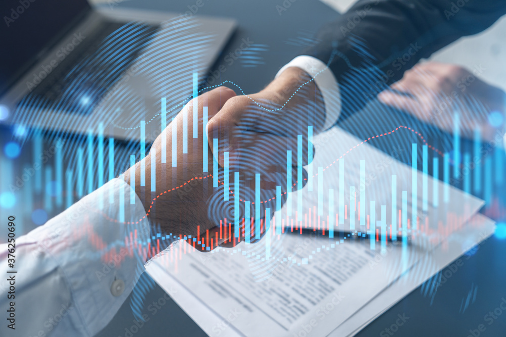 Multiexposure of two businesspeople handshake and forex graph hologram drawing background. Concept of financial market. Formal wear. Multiexposure of two businesspeople handshake and forex graph hologram drawing background. Concept of financial market. Formal wear.