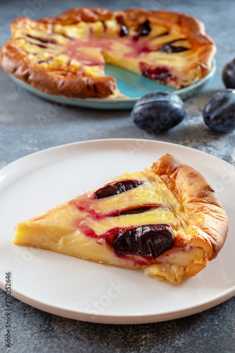 Clafoutis with plums is a French dessert that combines features of a casserole and pie. Fruits in a sweet pancake-like egg batter are baked in casserole dishes.