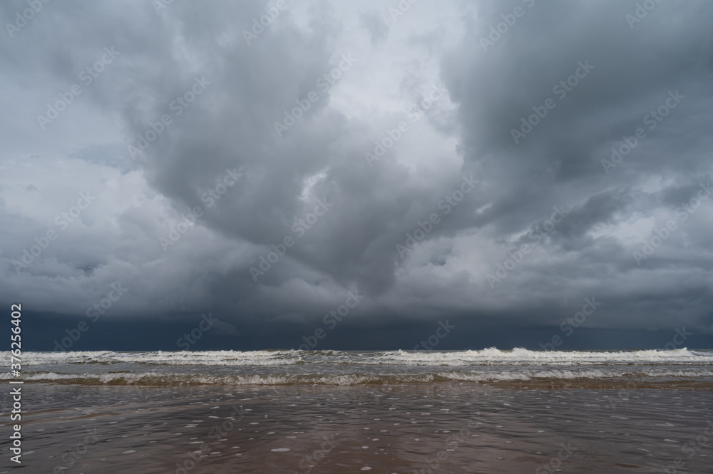 Storm clouds over the sea.The waves hit to the beach before rainy on seascape background.Bad weather for outdoor travel.