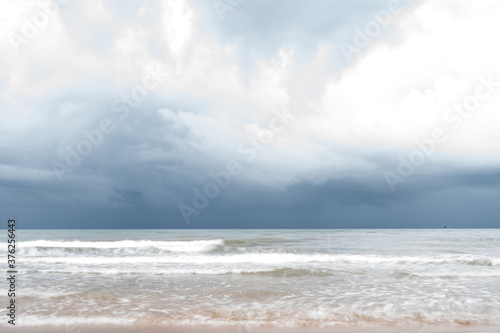 Storm clouds over the sea.The waves hit to the beach before rainy on seascape background.Bad weather for outdoor travel.