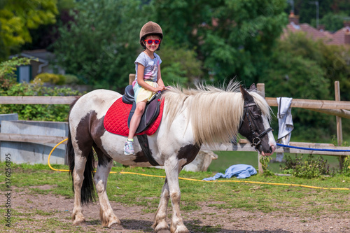 Horseback riding, lovely equestrian - young girl is riding a horse © max