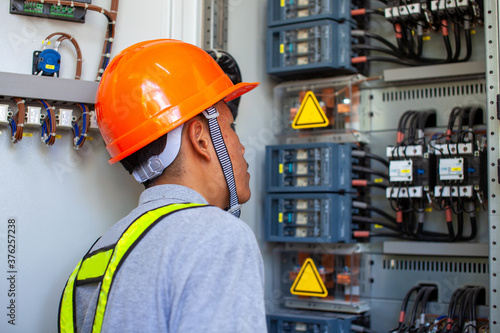 Electrician inspect in front of fuse switch board system.