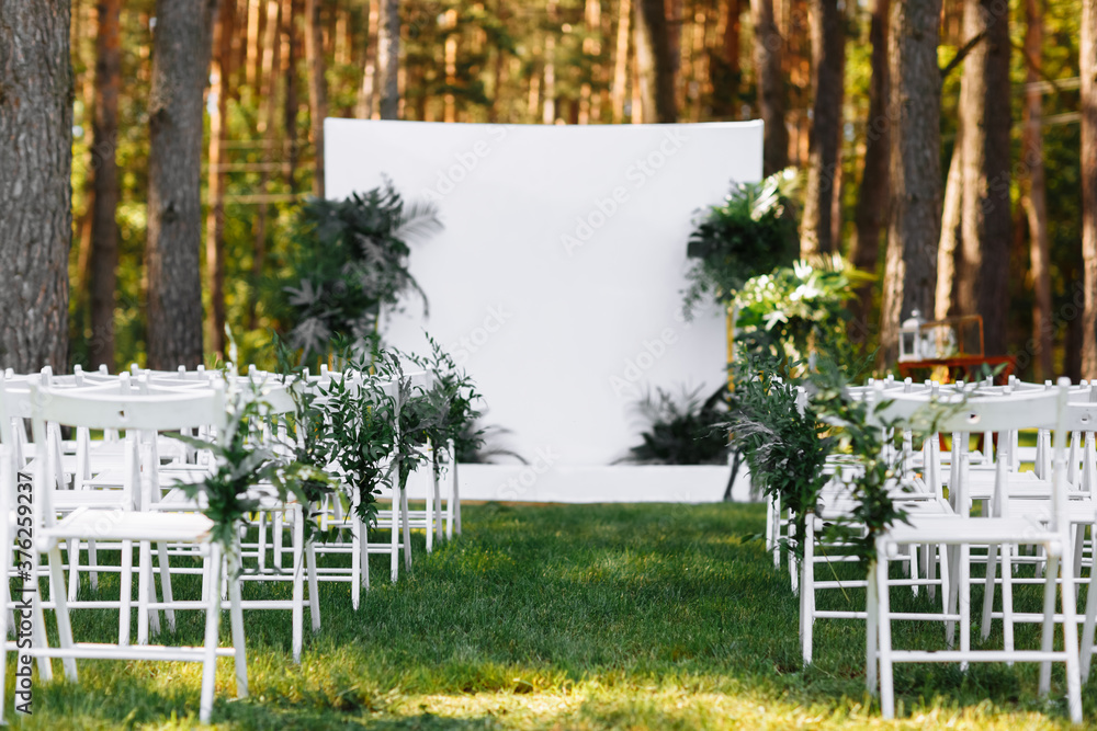 Beautiful wedding set up. Area of the wedding ceremony. Cute, trendy rustic decor. Part of the festive decor, floral arrangement. blurred background. selective focus Beautiful wedding set up. Area of the wedding ceremony. Cute, trendy rustic decor. Part of the festive decor, floral arrangement. blurred background. selective focus