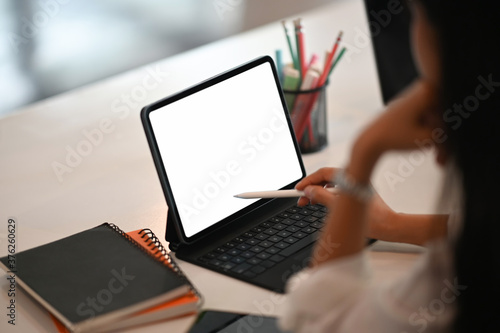 Cropped shot stylish woman holding digital pen posing on empty screen of digital tablet.