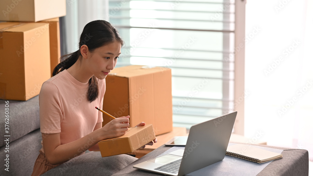Owner online business writing costumer address on box. SME business startup and online market concept. Owner online business writing costumer address on box. SME business startup and online market concept.
