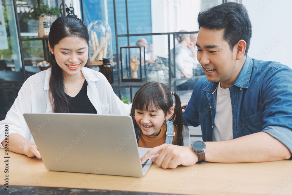 Happy family using laptop together at living room,Parents watching movie with child. Happy family using laptop together at living room,Parents watching movie with child.