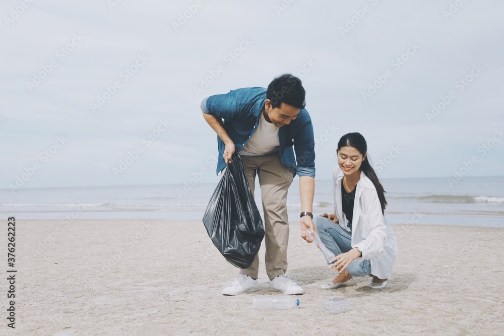 Young couple people cleaning beach area, Young Volunteer cleaning beach. Young couple people cleaning beach area, Young Volunteer cleaning beach.