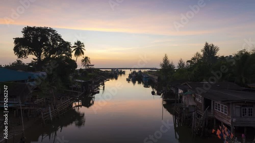 4K time lapse sunrise view of fisherman village beside the river through the sea from Samet bridge in morning in chumphon province, Thailand photo