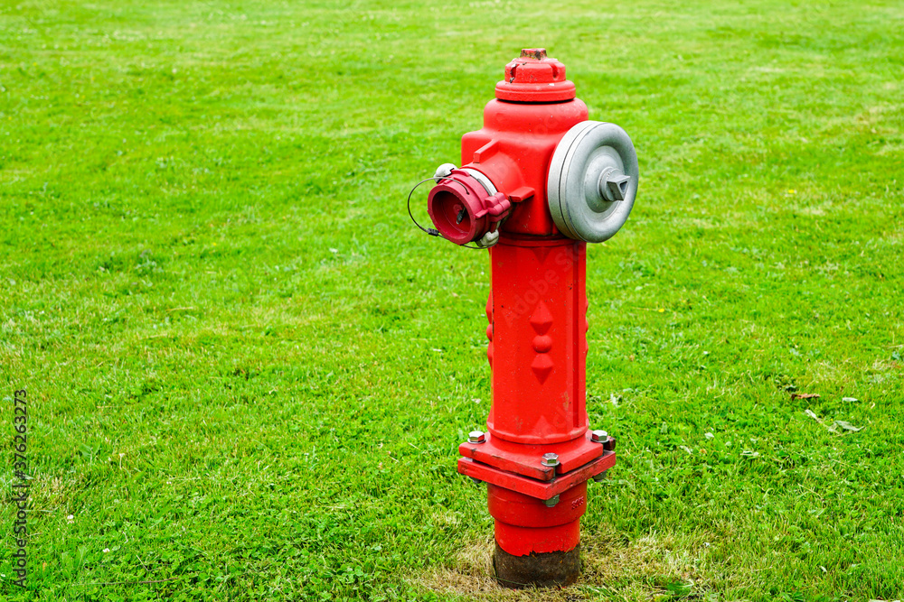 red isolated fire hydrant sits in a freshly cut grass field