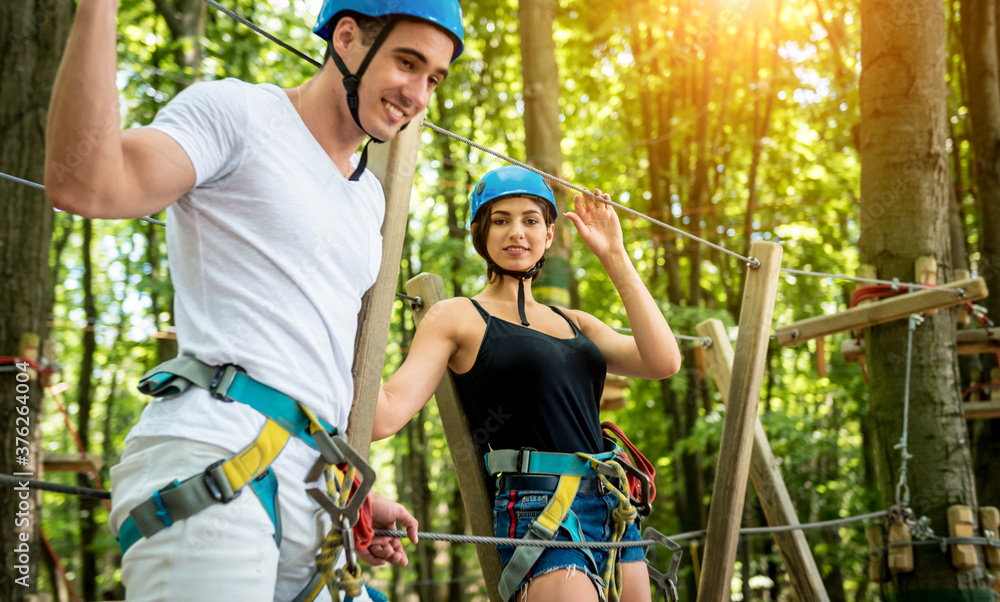 Fototapeta premium Young couple having fun time in adventure rope park.