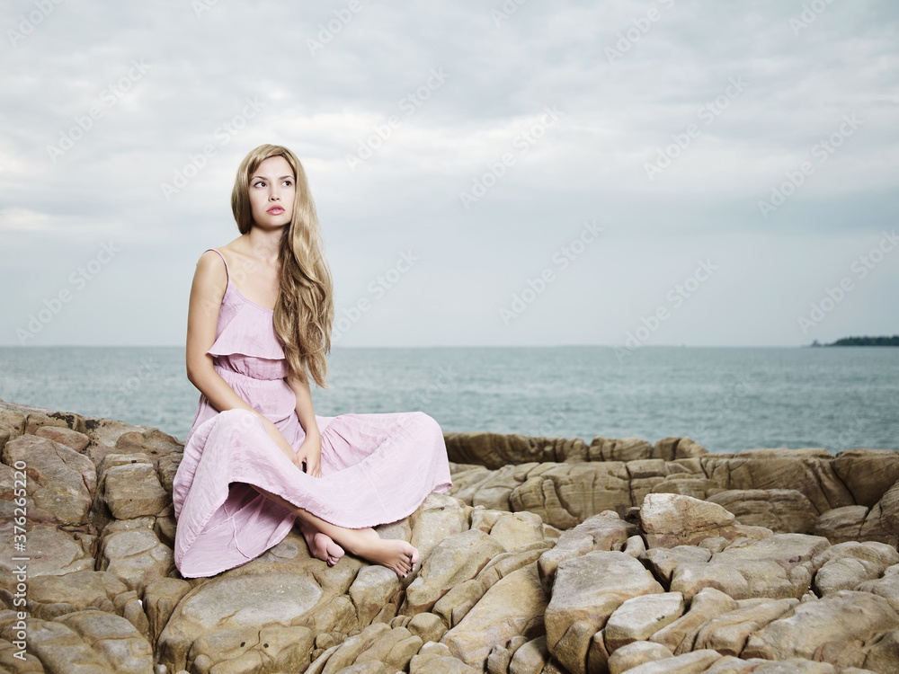 Beautiful blonde woman on the beach. Lady in pink dress Beautiful blonde woman on the beach. Lady in pink dress