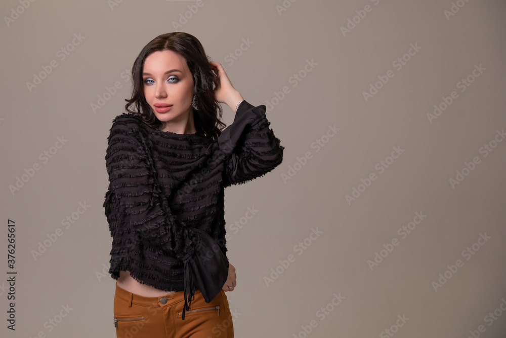 Beautiful young girl smiles and poses on brown beige background. Copy space Beautiful young girl smiles and poses on brown beige background. Copy space