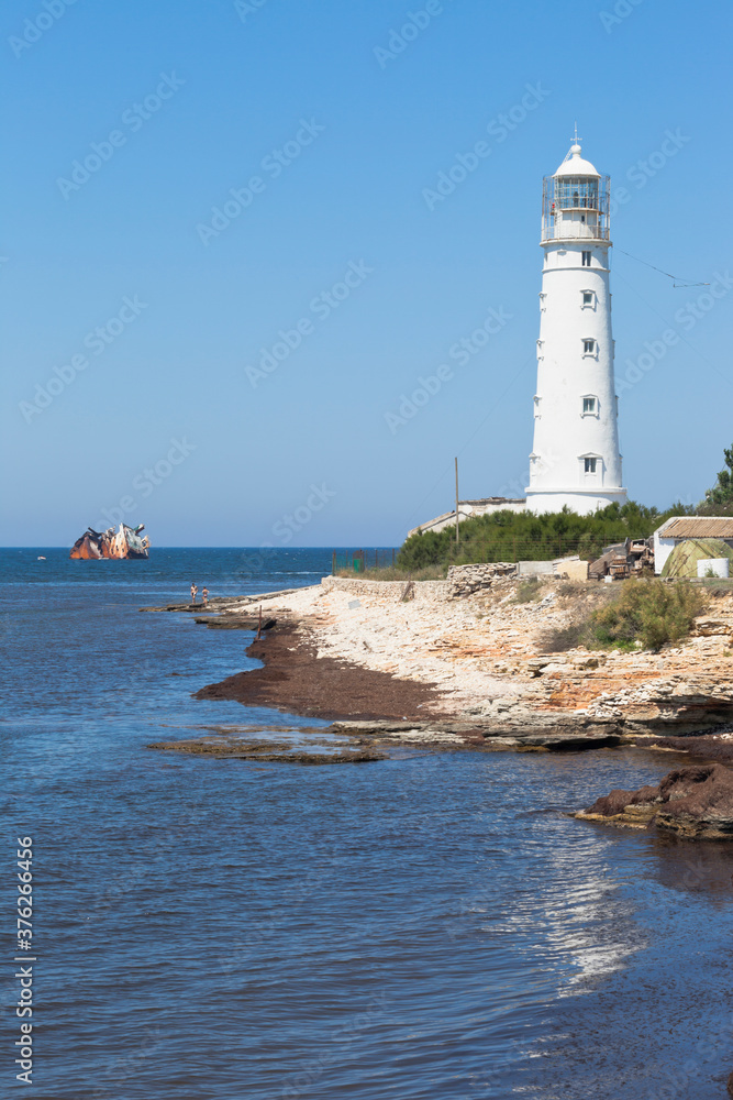 Tarkhankut lighthouse and the skeleton of the Cambodian dry cargo ship Ibrahim Yakim, stranded by a storm, Crimea