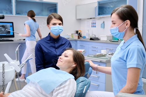 Examination, treatment of teeth, patient mature woman in dental chair