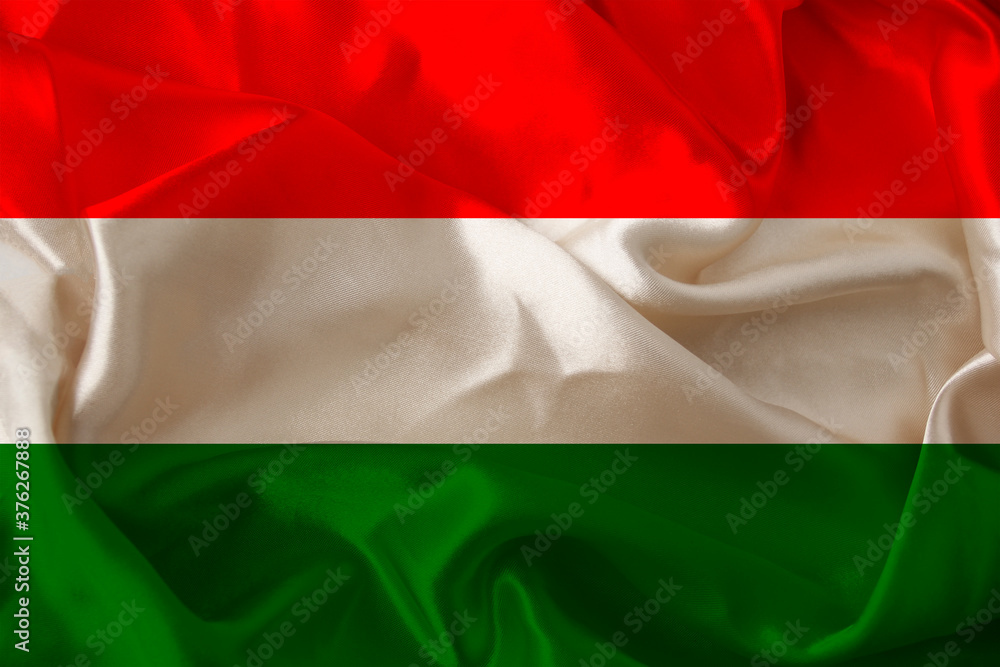 beautiful photo of the colored national flag of the modern European state of Hungary on textured fabric, concept of tourism, emigration, economics and politics, closeup