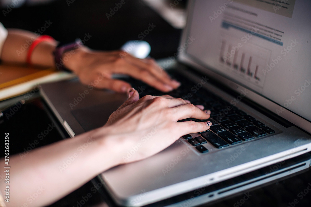 Young slender girl at the restaurant table works behind a laptop Young slender girl at the restaurant table works behind a laptop