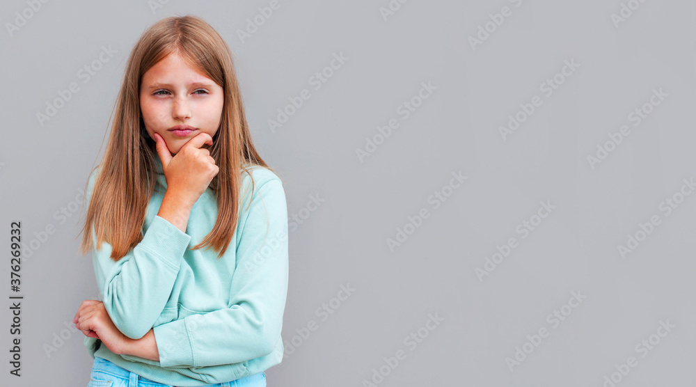 Thoughtful attractive young woman thinking and looking away over gray background Thoughtful attractive young woman thinking and looking away over gray background