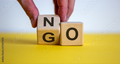 Wallpaper Mural Hand flips a cube and changes the word 'no' to 'go'. Beautiful yellow table, white background. Concept. Copy space. Torontodigital.ca