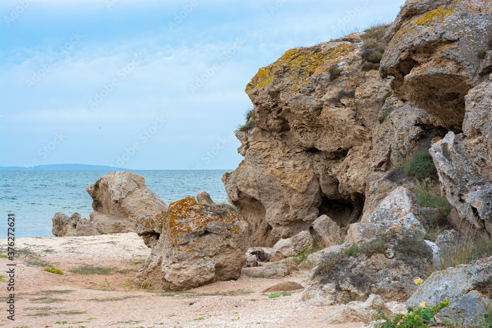Massive stone rocks in the sea during cloudy weather Massive stone rocks in the sea during cloudy weather
