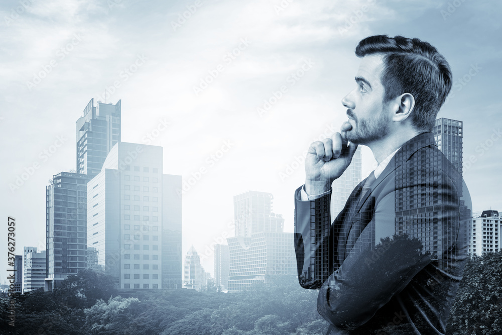 Young handsome businessman in suit with hand on chin thinking how to succeed, new career opportunities, MBA. Bangkok on background. Double exposure. Young handsome businessman in suit with hand on chin thinking how to succeed, new career opportunities, MBA. Bangkok on background. Double exposure.