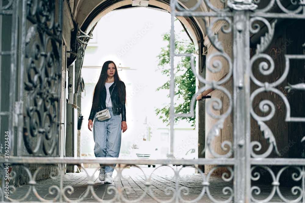 Young woman going out of vintage building.