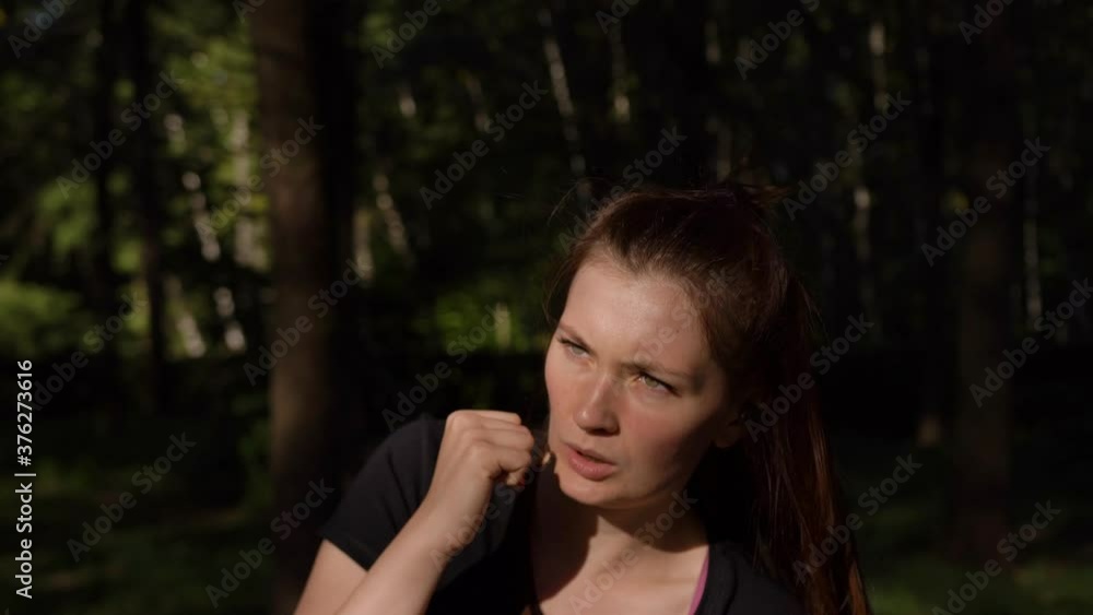 Girl black T-shirt bundle her head engaged in kickboxing in park, in forest, in early morning dawn. Boxing, training with punches, hitting apercuts. Outdoor cardio workout. Art of martial arts, combat Girl black T-shirt bundle her head engaged in kickboxing in park, in forest, in early morning dawn. Boxing, training with punches, hitting apercuts. Outdoor cardio workout. Art of martial arts, combat