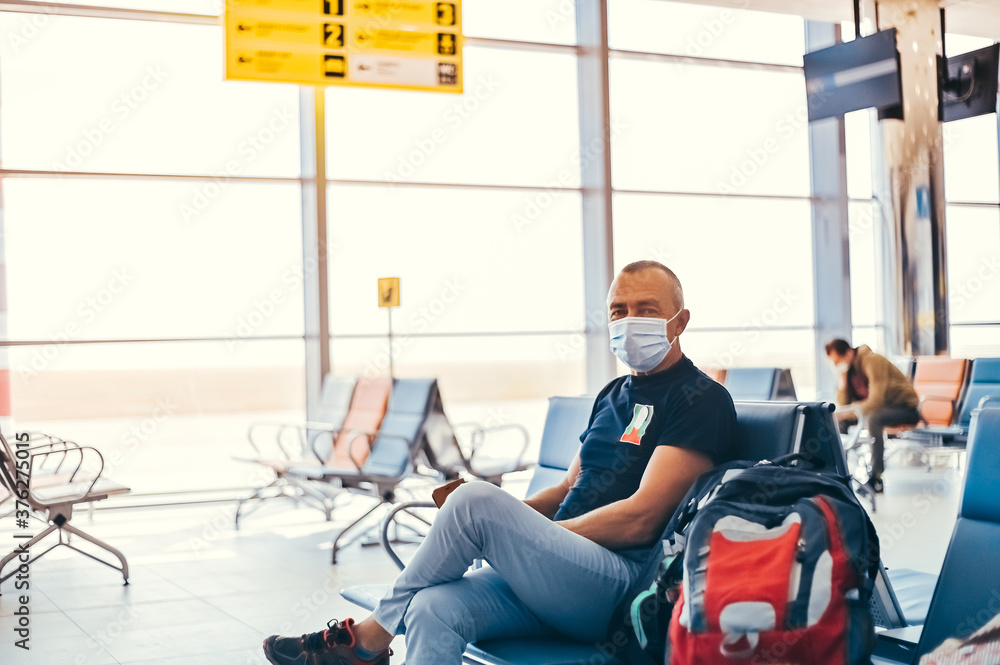 Fototapeta premium Airport attractive old man tourist boarding plane taking a flight wearing face mask. Coronavirus flu virus travel concept banner panorama.