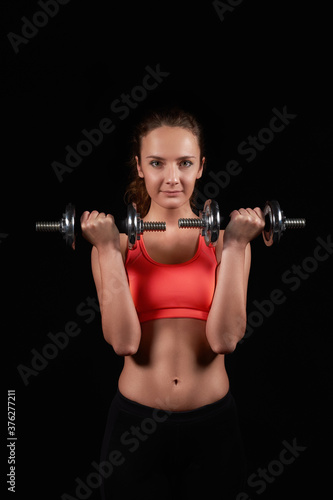 pretty caucasian fitness woman on black isolated background in studio