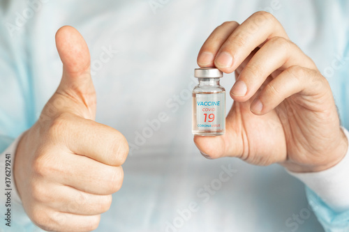 Vial with usa, american vaccine for covid-19 coronavirus,flu, infectious diseases.Vaccination support,approval.Hand of doctor.Thumb up.Clinical trials of injection for administration for human,people