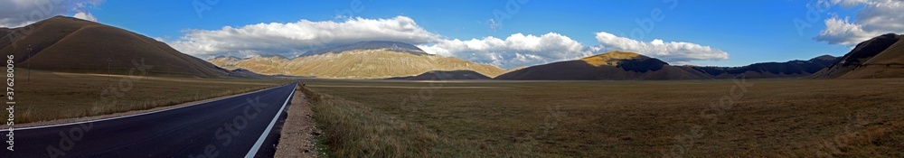 Wonderful overview of the plain of castelluccio in central Italy, surrounded by the Sibillini mountains and sky with powerful clouds