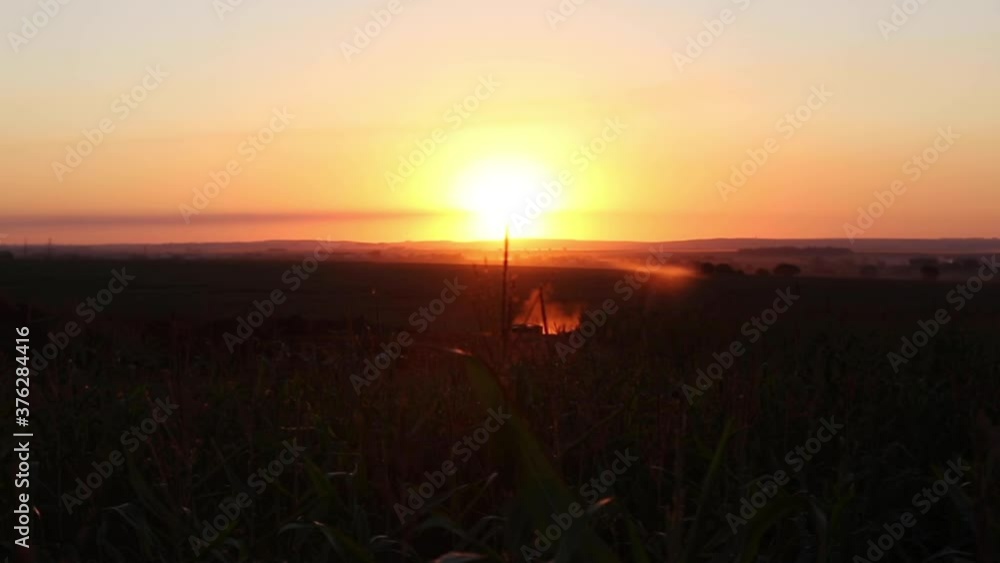 Truck raising dust on a dirt road in a rural area during a beautiful orange sunset in the city of Maringá, Paraná, Brazil Truck raising dust on a dirt road in a rural area during a beautiful orange sunset in the city of Maringá, Paraná, Brazil