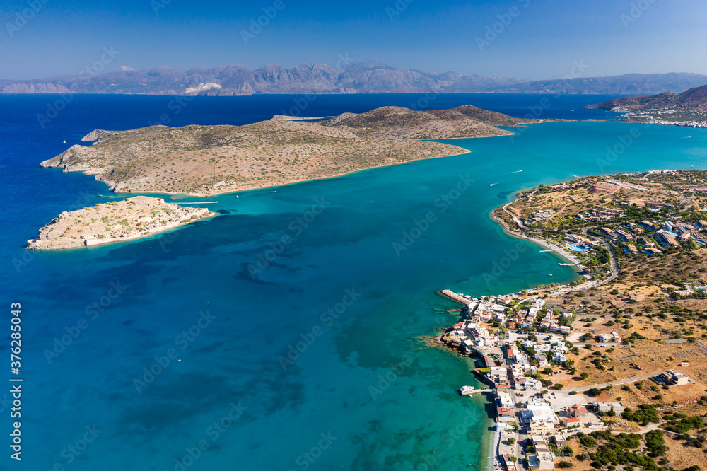 Aerial view of the medieval fortress of Spinalonga island and town of Plaka with crystal clear seas (Crete, Greece)