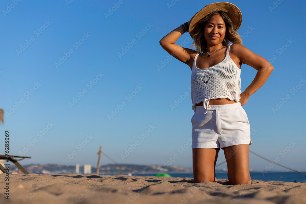 Beautiful Vietnamese woman alone playing and relaxing on the beach. Asian woman on holiday in a luxury resort in Portugal traveling alone around the world. Woman's lifestyle concept of freedom Beautiful Vietnamese woman alone playing and relaxing on the beach. Asian woman on holiday in a luxury resort in Portugal traveling alone around the world. Woman's lifestyle concept of freedom