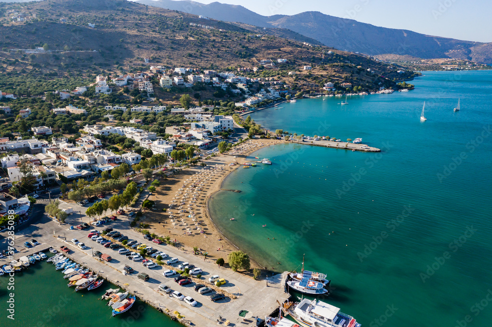 ELOUNDA, CRETE, GREECE - 27 AUGUST 2020: Aerial view of the public beach in the popular Greek tourist town of Elounda on the island of Crete
