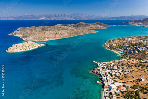 Aerial view of the medieval fortress of Spinalonga island and town of Plaka with crystal clear seas (Crete, Greece)