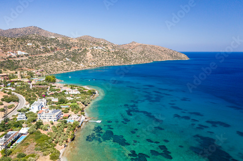Aerial drone view of a beach surrounded by crystal clear shallow ocean  Haviana Beach  Crete  Greece 