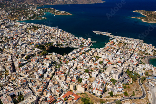 Fototapeta Naklejka Na Ścianę i Meble -  Aerial view of the picutresque town of Aghios Nikolaos in Crete (Greece) surrounded by crystal clear ocean