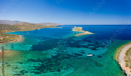 Aerial view of the coastline of Crete surrounded by the clear waters of the Aegean Sea in summer