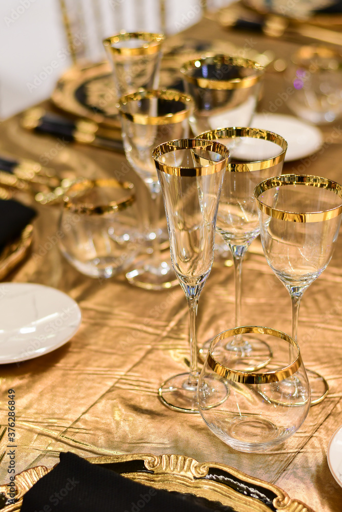 Luxury hotel table setting crystal wine glass and gold forks and knives. Catering banquet. table decor for celebration Wedding, anniversary, christmas, new year. table settin g restaurant.