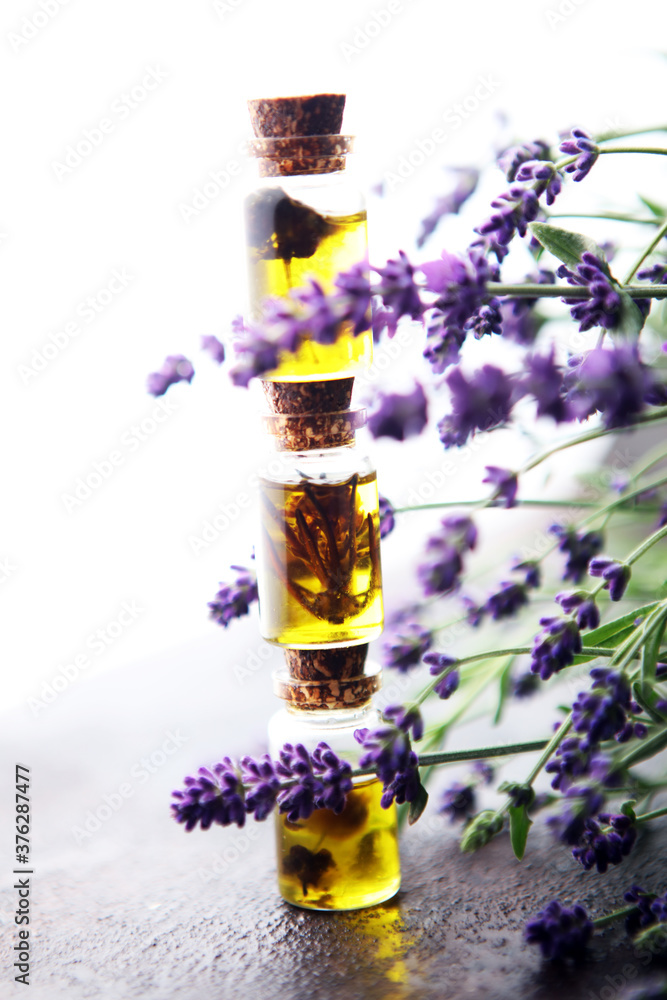 lavender oil in a glass bottle on a background of fresh flowers. lavender oil in a glass bottle on a background of fresh flowers.
